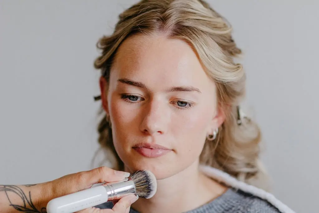 Foundation wird für das Braut-Make-up mit dem Pinsel aufgetragen