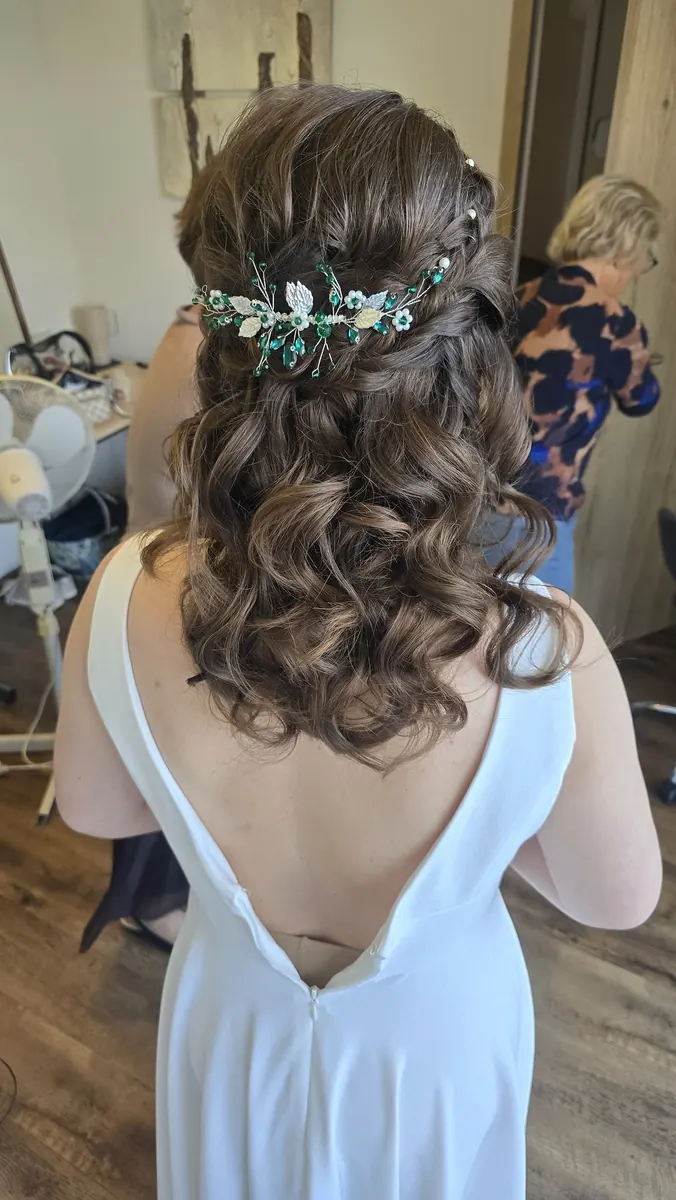 Halboffene Brautfrisur mit Locken und Blütenranke
