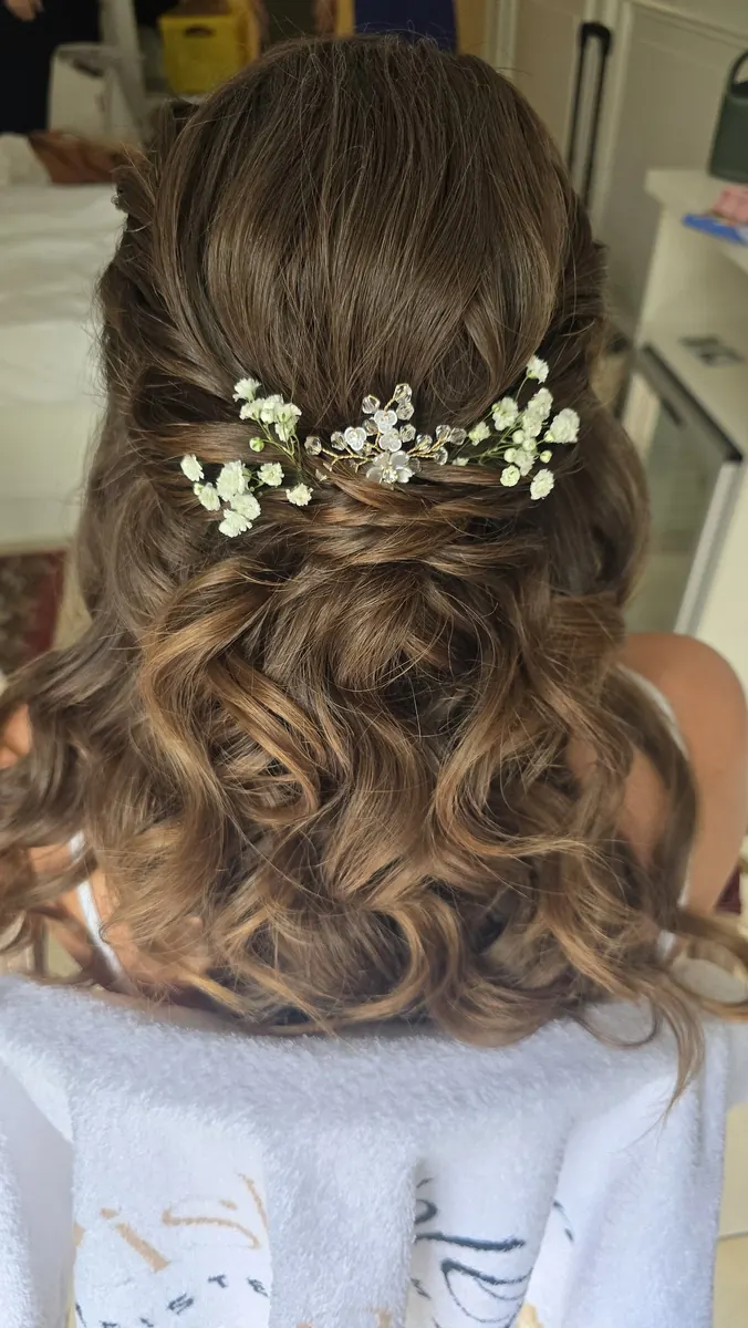 Halboffene Brautfrisur mit weichen Locken und Schleierkraut