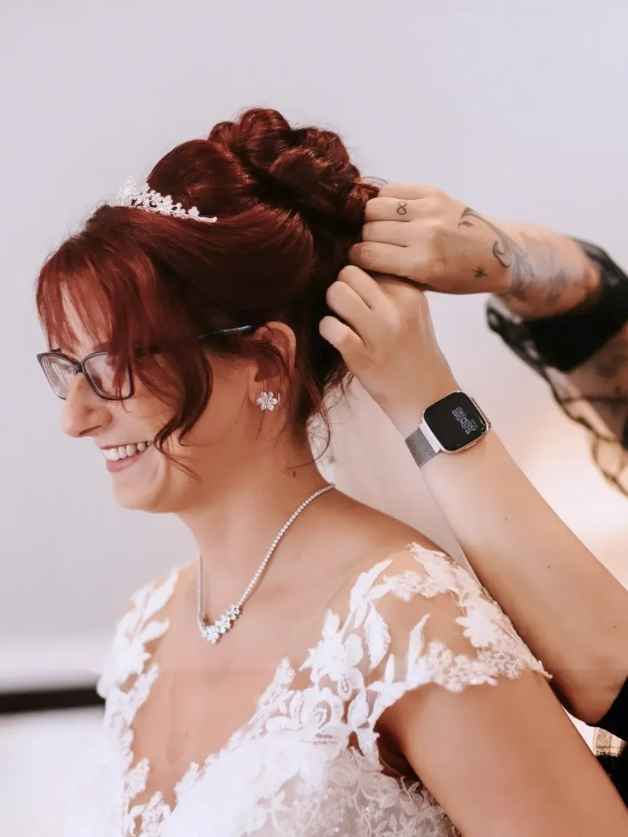 Letzte Handgriffe an einer Hochsteckfrisur mit Diadem