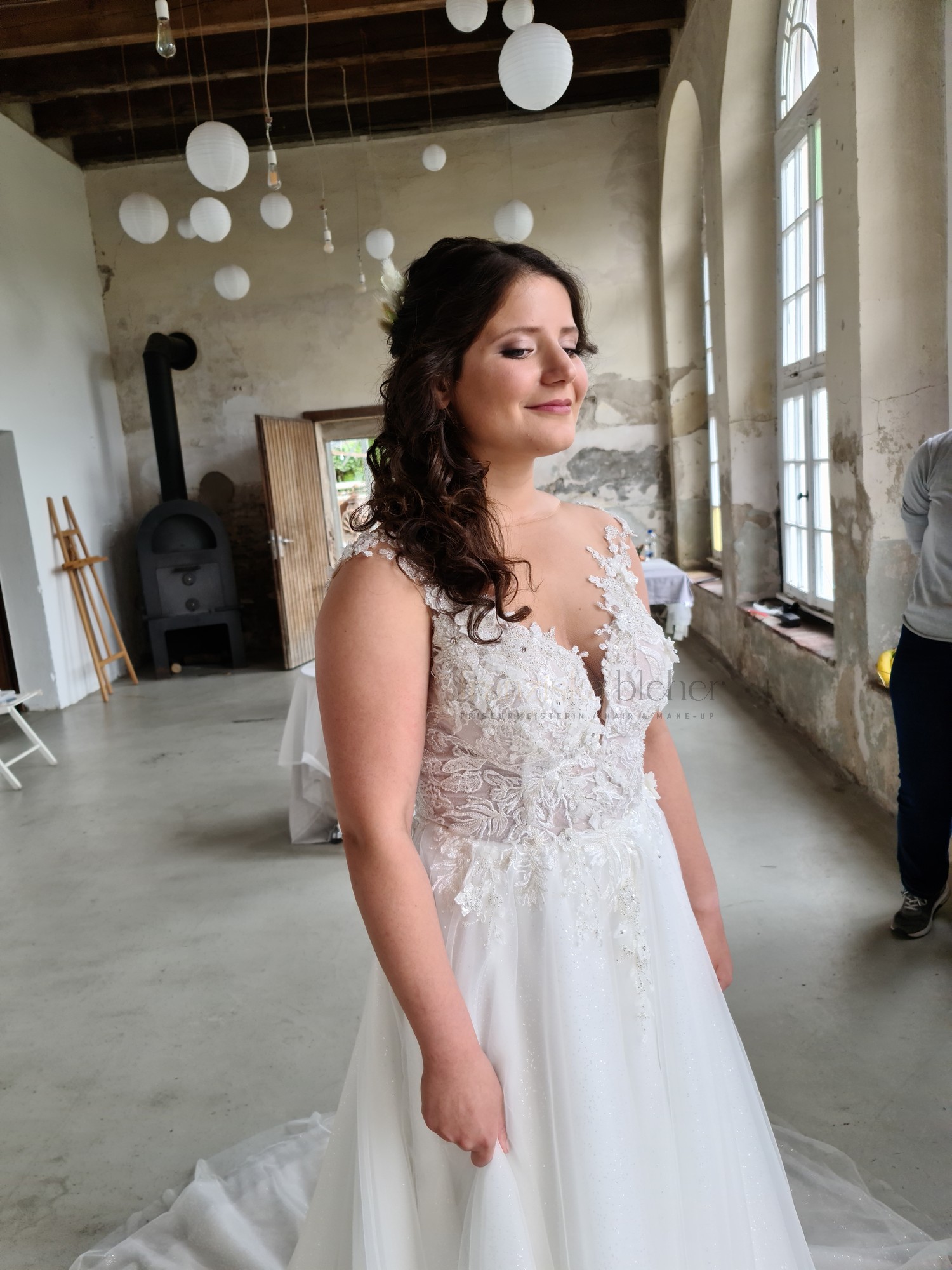 Braut mit halboffener Lockenfrisur und natürlichem Braut-Make-up in einer Hochzeitslocation am Niederrhein